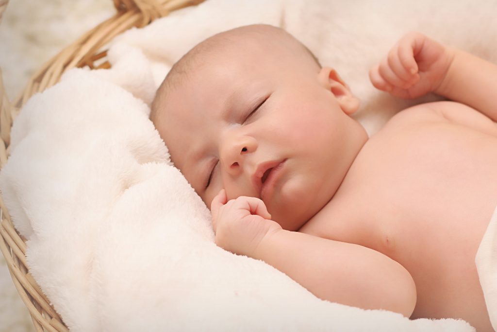 Bebé duerme sin pañal para aliviar su dermatitis del pañal.